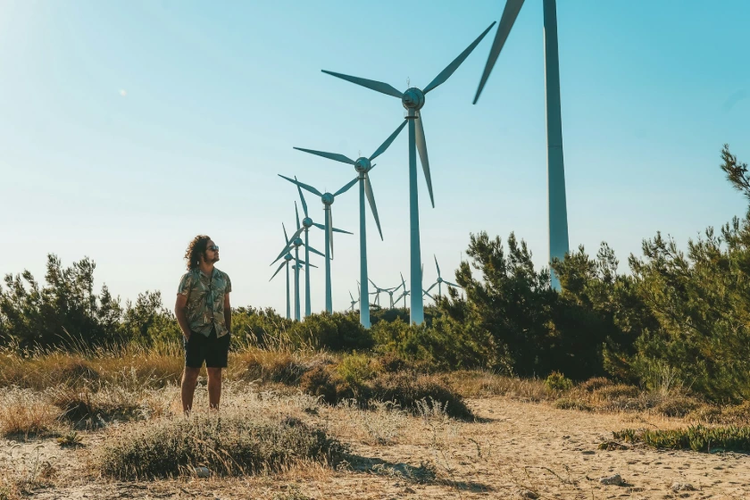 a person standing in front of windmills